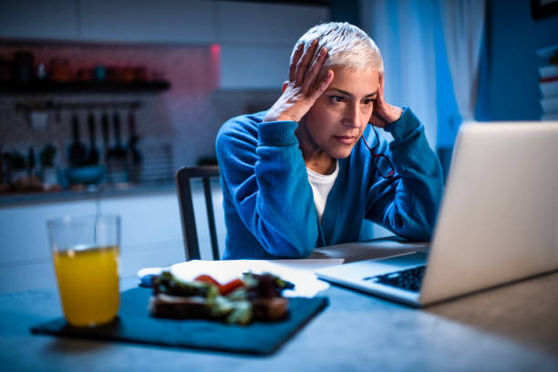 istock Elderly woman coping with stress while working from home late at night 1216552691