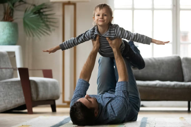 istock Young dad lifting small playful child son in air. 1216554322