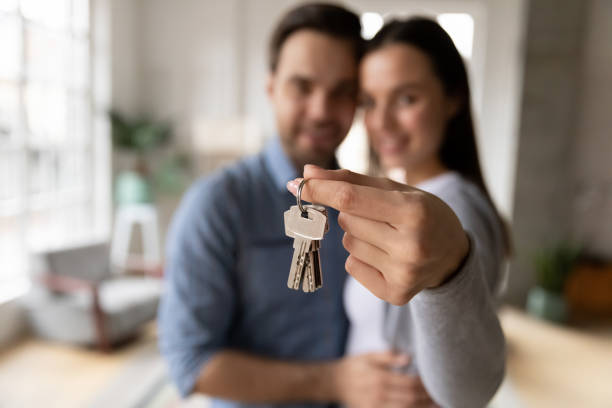 istock Focus on keys, held by excited young homeowners. 1216554365