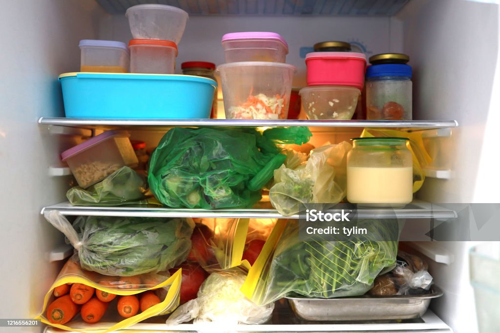 Food inside a refrigerator Plastic bag and container with food in refrigerator. Refrigerator Stock Photo