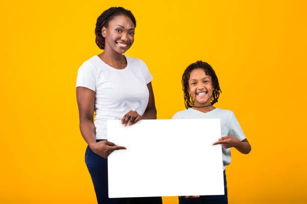 istock Happy family holding white placard at yellow studio 1216558129