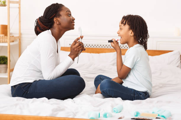 istock Little afro girl doing makeup with her mom 1216558225