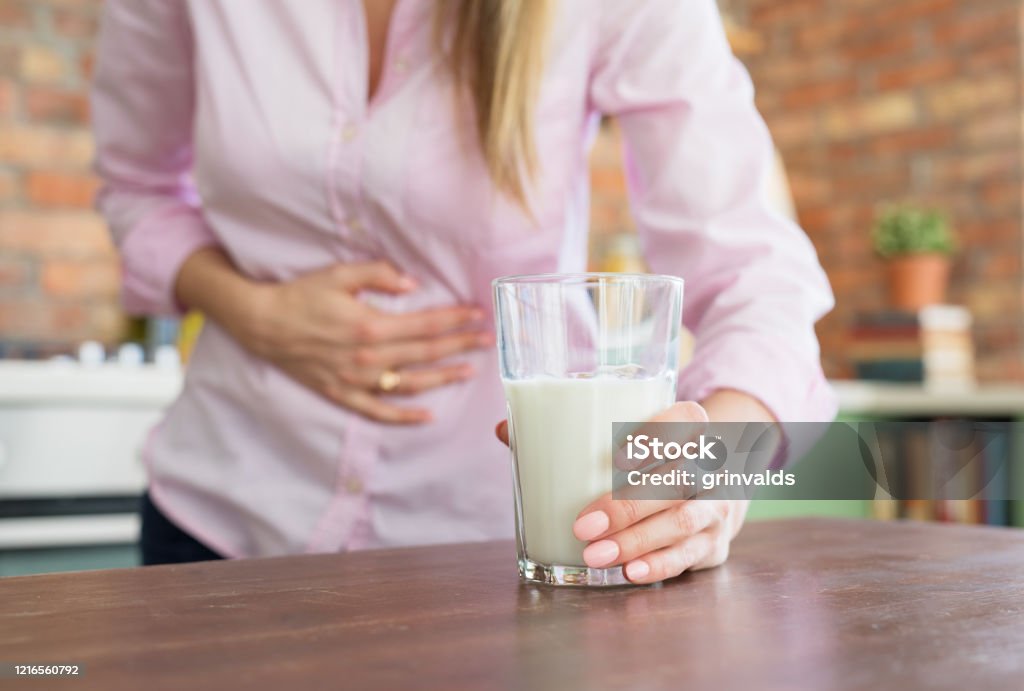 Woman feeling sick by drinking milk Woman having pain in stomach, feeling sick by drinking milk Lactose Fermentation Stock Photo