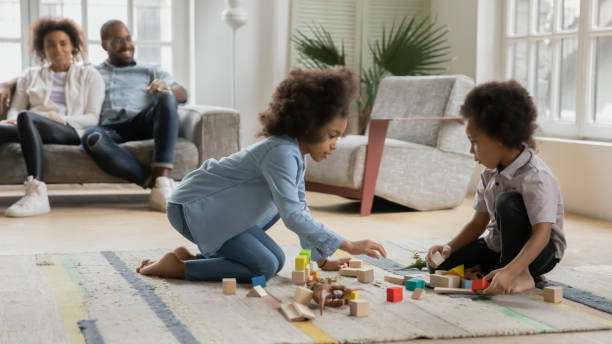 istock African kids play on floor parents resting on sofa 1216562007