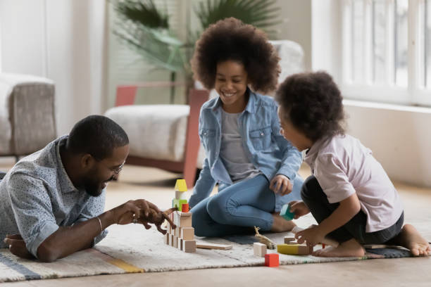 istock African dad play with kids on warm floor at home 1216562013