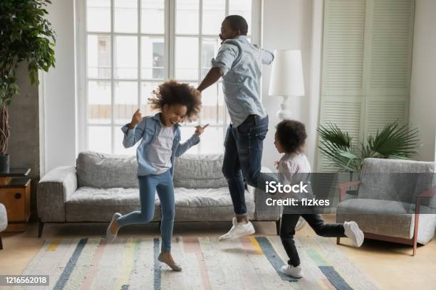 African Father Son And Daughter Listening Music Dancing At Home Stock Photo - Download Image Now