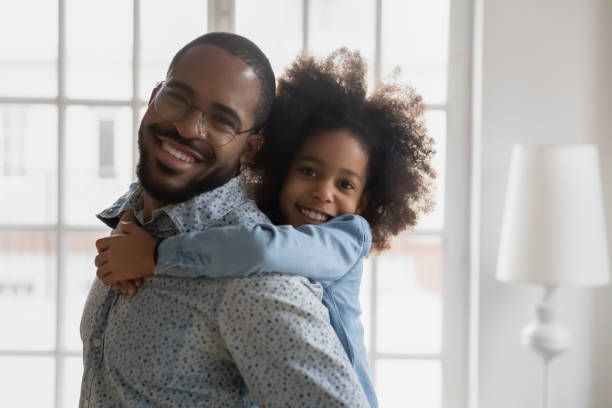 istock African ethnicity daughter looking at camera piggybacks young handsome father 1216562023