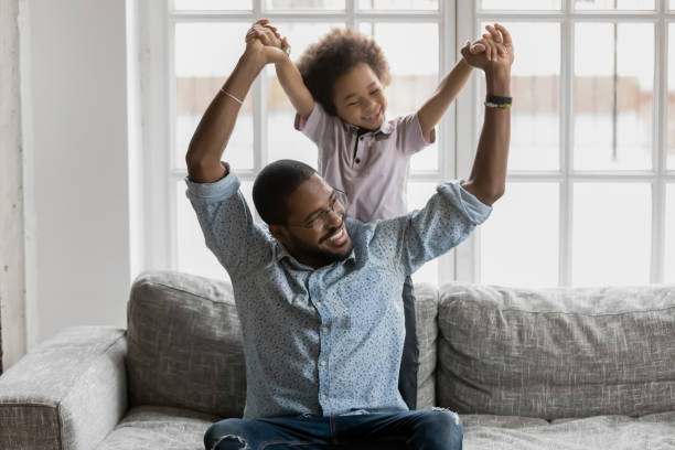 istock African loving father sitting on couch playing with little son 1216562038
