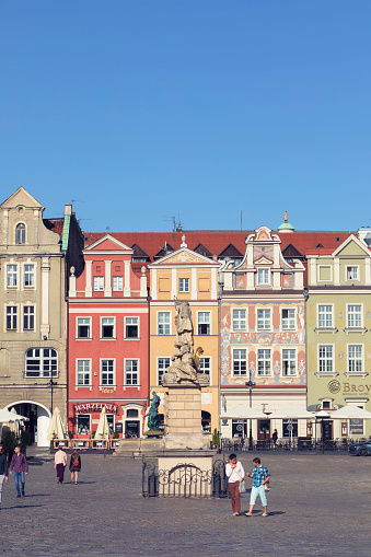 People on the old market square (Stary Rynek) in the historical old town of Poznan, Poland. In the center stands a a monument to Saint John of Nepomuk from 1724.