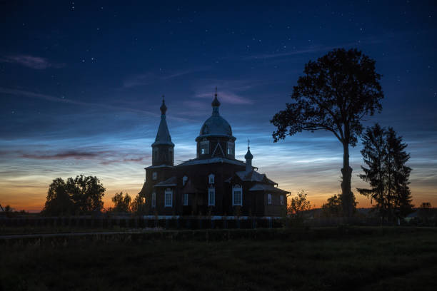 Old church under rare type of clouds - high-altitude noctilucent clouds