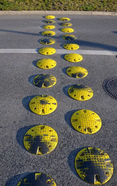 traffic element retarder yellow round points in two rows on a road asphalt lawn