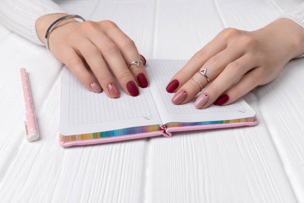 istock Womans hands with minimal pink spring summer manicure design on office table 1216566904