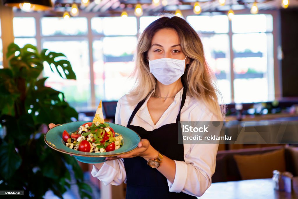Happy waitress working at a restaurant, COVID - 19 Concept. Restaurant Stock Photo
