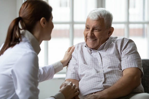 istock Nurse talks to old patient holds his hand showing kindness 1216570519