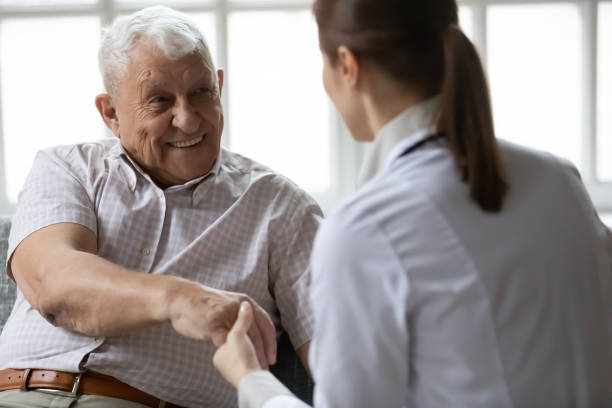 istock Nurse in uniform talking during day visit to elderly patient 1216570527
