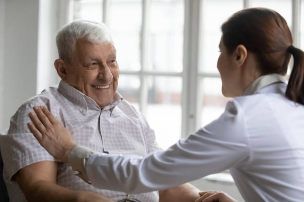 istock Old man patient and careful nurse communication indoors 1216570540