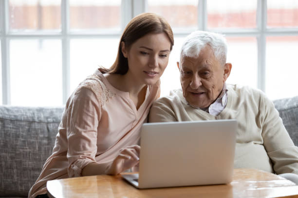 figlia adulta vecchio padre scegliere servizi via internet utilizzando il computer - computer child family laptop foto e immagini stock