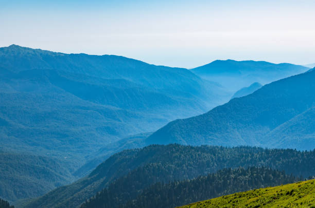 istock View over the Green Valley, surrounded by high mountains on a summer sunset. Layers of mountains in the haze during sunset. 1216570693