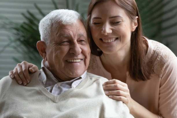 istock Closeup image candid grown up daughter hugs elderly father 1216570694