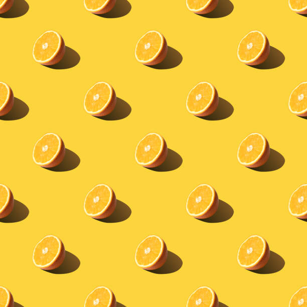 istock Seamless pattern of half orange sliced on yellow color background. Minimal. 1216571870