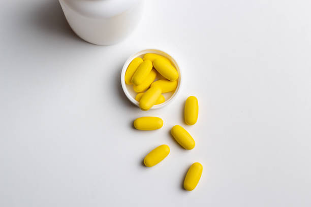 istock Yellow pills on white background 1216573063