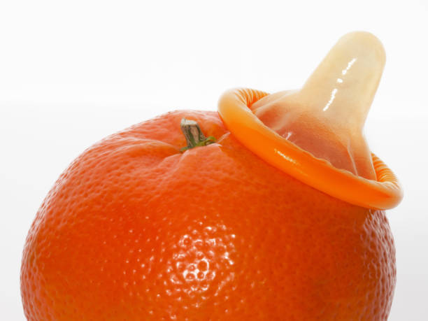 istock Unwrapped color condom with fruit flavor and orange 1216573809