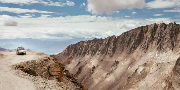 Off-road vehicle auto going through high altitude Mountain pass on Leh - Manali road in Northern Indian Himalaya, Ladakh region.