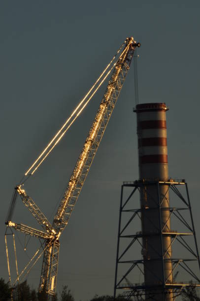 istock Power plant. Crane at a construction site. Chimney and smoke 1216577134
