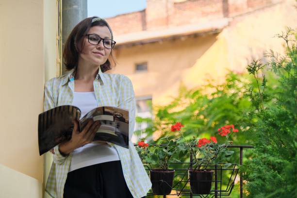 Mature woman standing on open balcony in isolation,