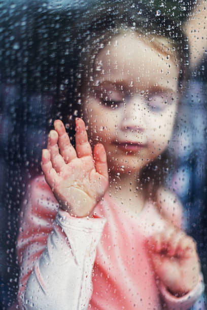 istock Girl With Hand on Window 1216579042