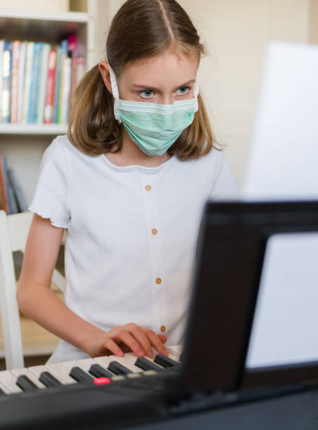 istock Little girl learning the piano during quarantine. 1216582418