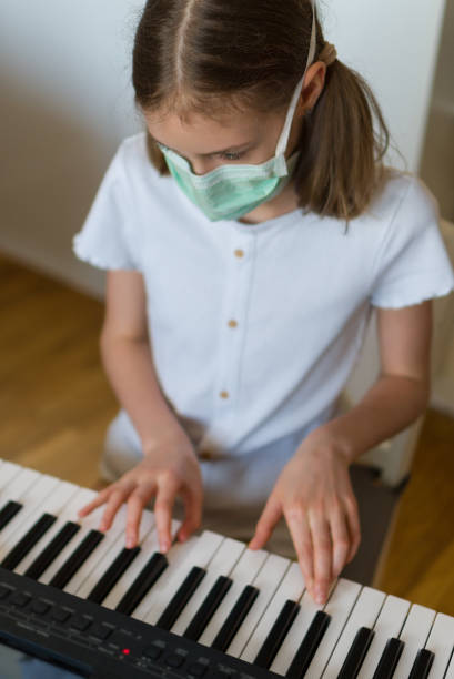 istock Little girl learning the piano during quarantine. 1216582426