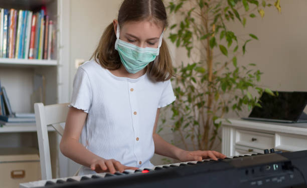 Little girl learning the piano during quarantine.