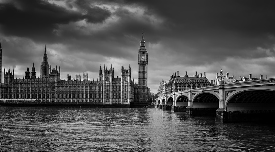 Looking across the Thames towards Big Ben and the Palace of Westminster. Dramatic black and white/film noir style.