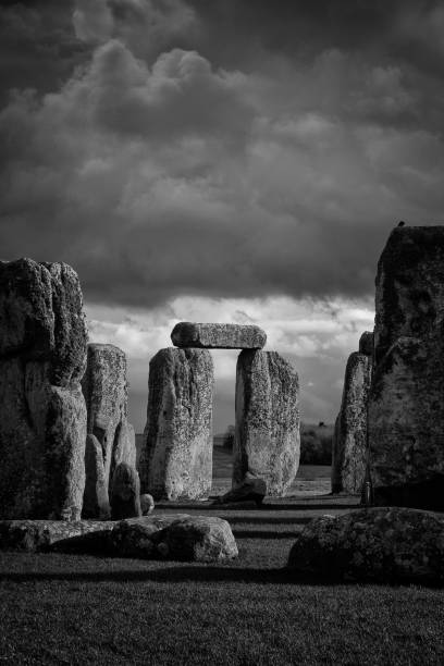 A dramatic sky looms over the ancient neolithic monument of Stonehenge in Wiltshire, England. Black & white conversion of an infrared image.