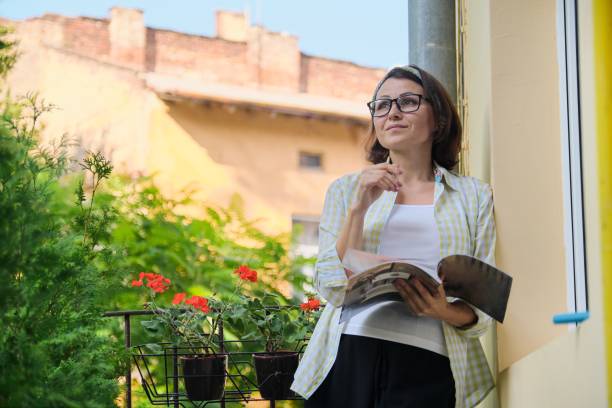 istock Mature woman standing on open balcony in isolation, 1216586489