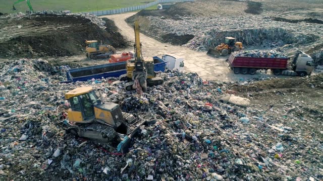 City Dump. The Bulldozer Moves Along the Landfill, Leveling the Garbage. Aerial View