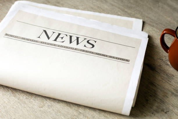 istock Newspaper and coffee on wooden background 1216588117