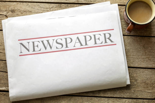 istock Newspaper and coffee on wooden background 1216588268