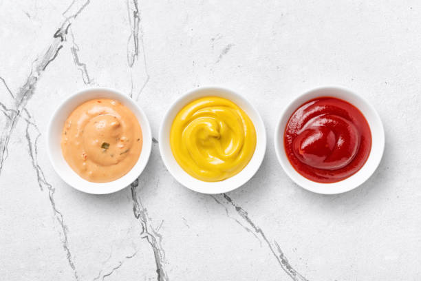 yellow mustard, red ketchup and paprika sauce in small bowls - sauces dip ketchup mayonnaise imagens e fotografias de stock