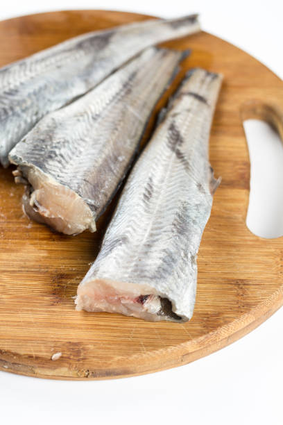 istock Fresh sliced hake fish filets on the cuting wooden board 1216589508
