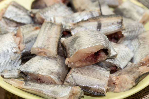 selektiver fokus auf geschnittenen seehechtfisch auf dem teller - merluza stock-fotos und bilder