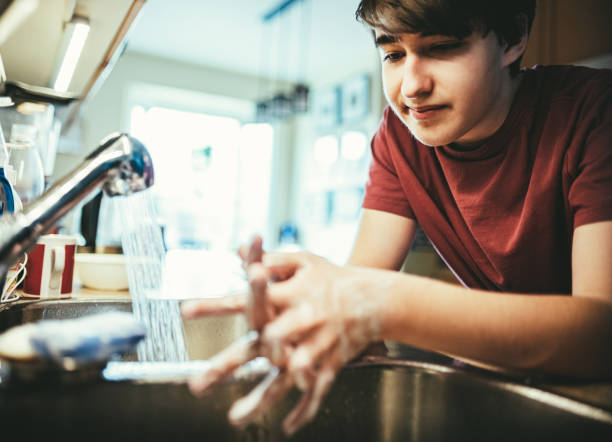 istock COVID-19, Teenager washing hands during lockdown 1216591493