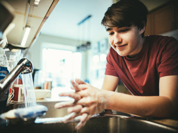 istock COVID-19, Teenager washing hands during lockdown 1216591777