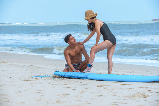 istock Asian surfer teacher man teach practice woman student during private surf class lesson. 1216594638