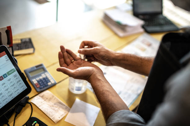 entrepreneur utilisant le gel d’alcool pour nettoyer et laver la main à sa petite entreprise - supermarket sales clerk retail cashier photos et images de collection