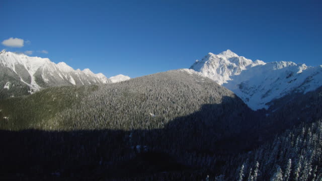 Panning Drone Shot of White Snow Covered Mountain Peaks