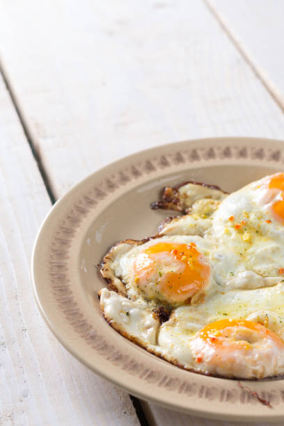 istock Homemade fried eggs on the plate above wooden table 1216596356