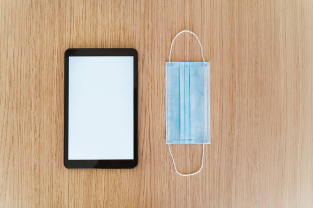 istock Top view of empty screen phone and protective face mask to prevent contagious covid 19 coronavirus disease. 1216596374