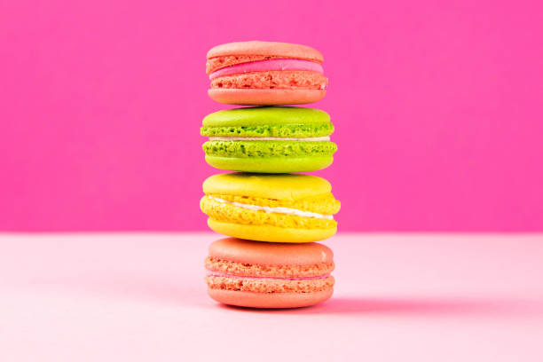 istock Multi-colored macaroons stand in a pile on a pink table 1216597328